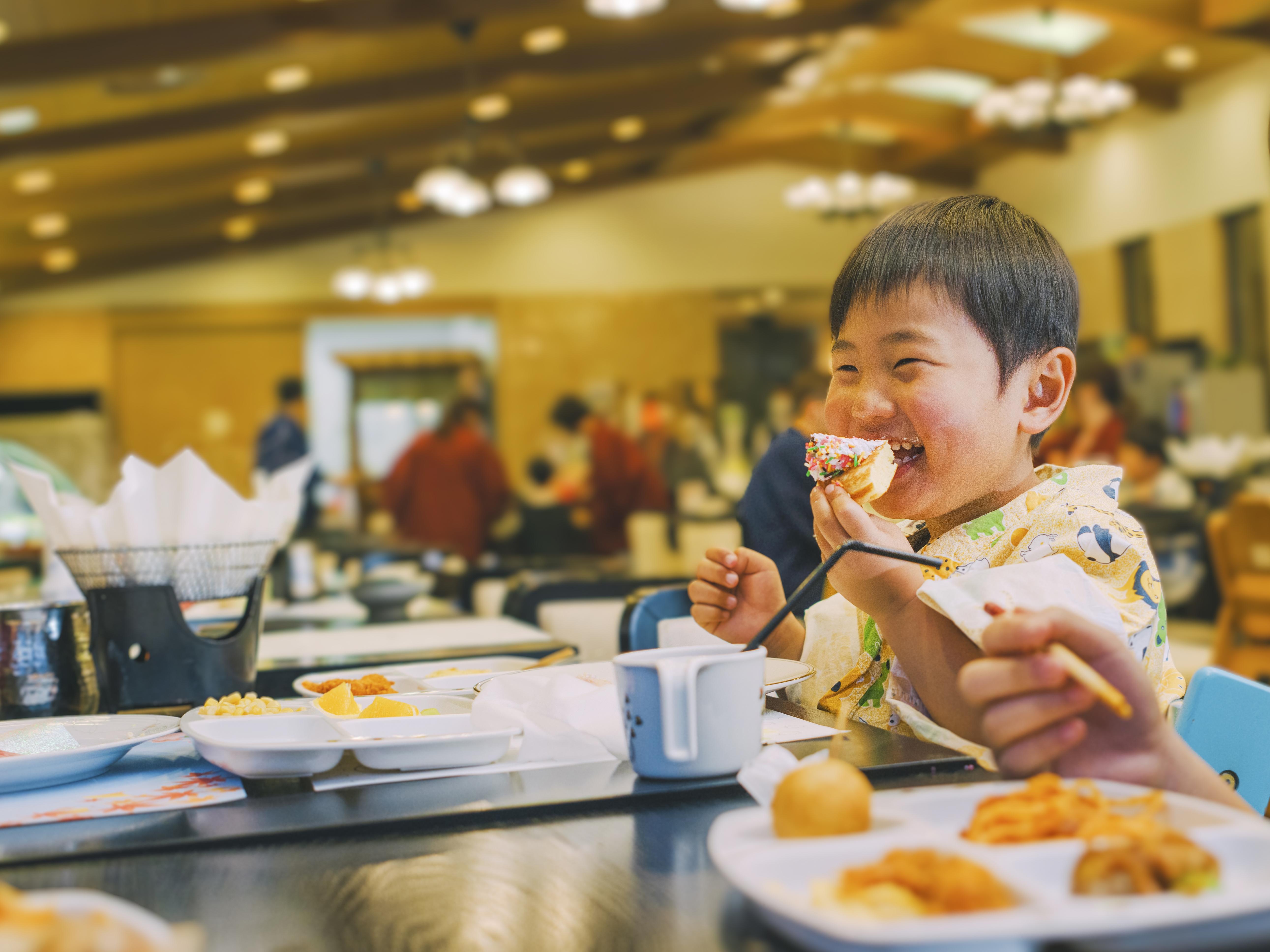 レストランで楽しそうに食事をするお子様